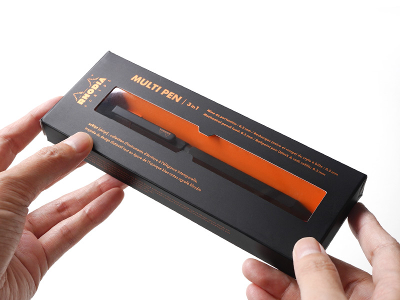 パッケージに入ったブラック色のペンを手に持っている様子