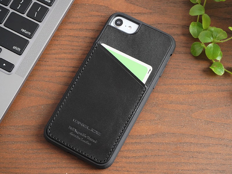 ブラック色のスマホケースを装着したiPhoneがデスク上にある様子